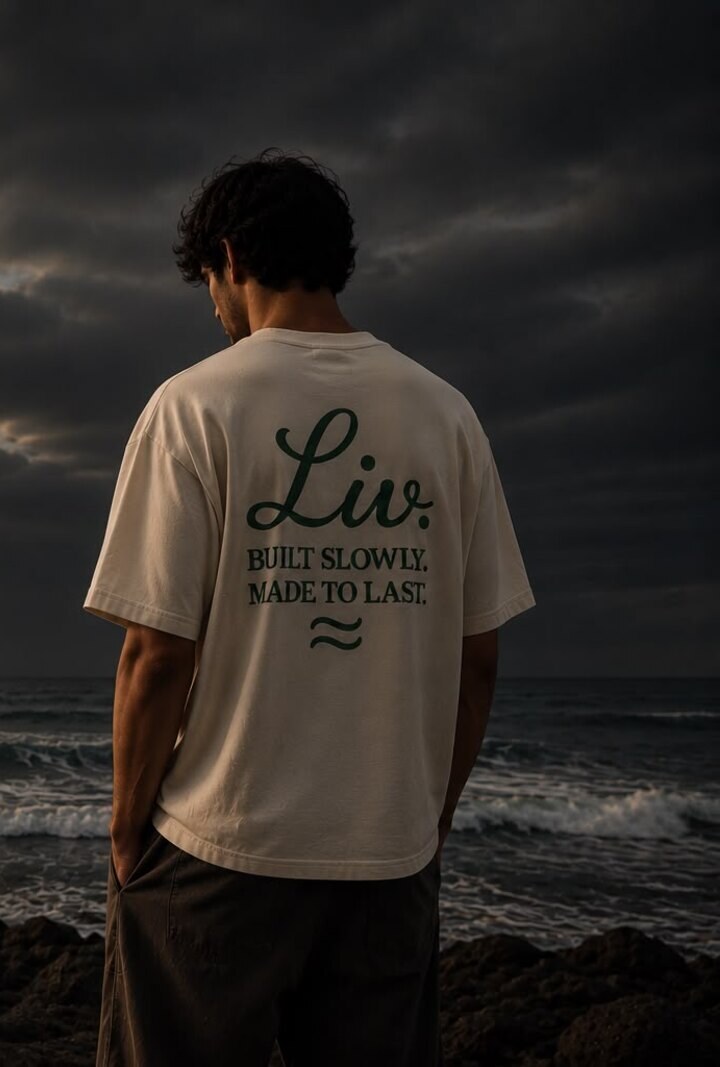 A figure at the shoreline wearing the Liv. tee