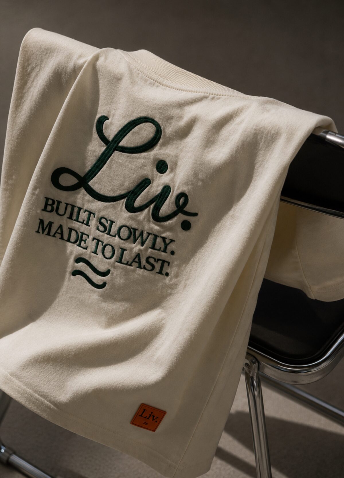 Liv. Script Statement Tee, draped in sunlight